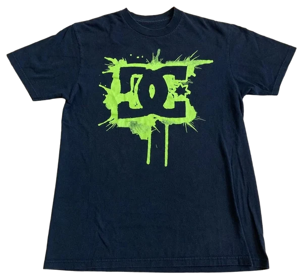Camiseta preta DC GREEN SPLASH esticada, estampa completa